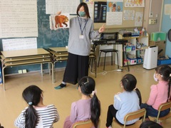 国際交流員の女性がイラストを持ちながら子供達に話をしている様子を写した写真