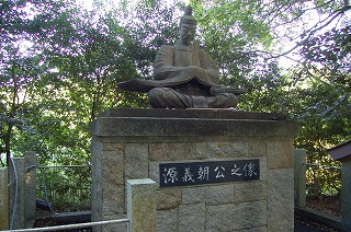 大きな石碑の上に座っている源義朝公の像を写した写真