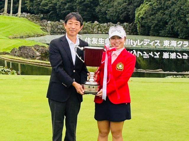優勝した佐久間朱莉プロが、町長と一緒に優勝トロフィーを持っている様子。