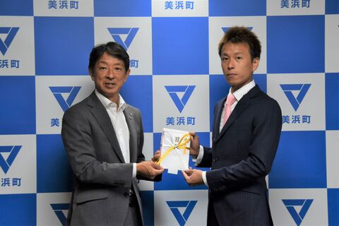 美浜町のバックボードの前で、磯部誠選手と町長が目録を一緒に持っている写真