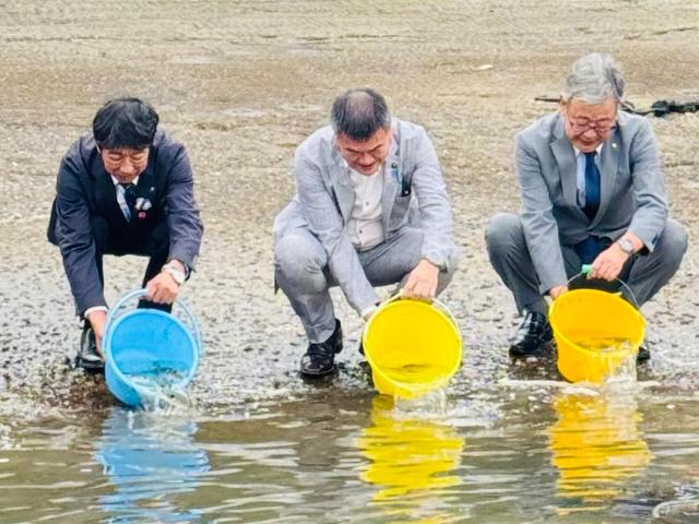 ふぐ慰霊祭において、横田県議会議員、町長、美浜町商工会会長がふぐを放流している様子。