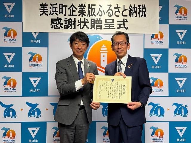 企業版ふるさと納税をして頂いた中日電気工業株式会社様へ感謝状をわたし、町長と代表の方が並んで写っている様子