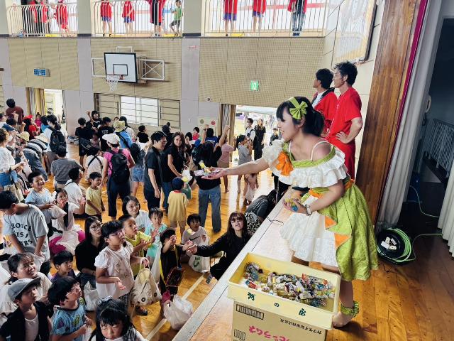 第7回mihamaふれあいまつりで布土小学校で子どもたちへ知多娘がお菓子を配っている様子