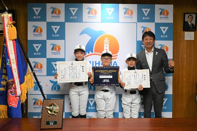 硬式野球の「三河リトルリーグ 知多チーム」に所属している3人が全国大会出場を報告し町長と並んでいる写真