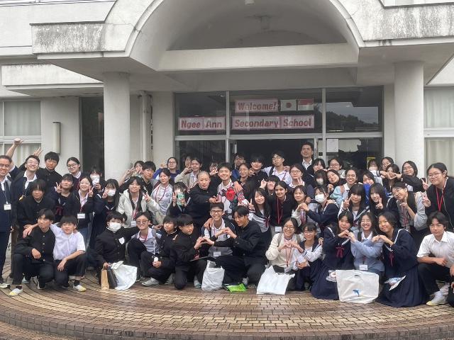 ニーアン中学校の生徒が河和中学校に来校した時の写真で両校の生徒が肩を組んだり手でハートをつくっている様子