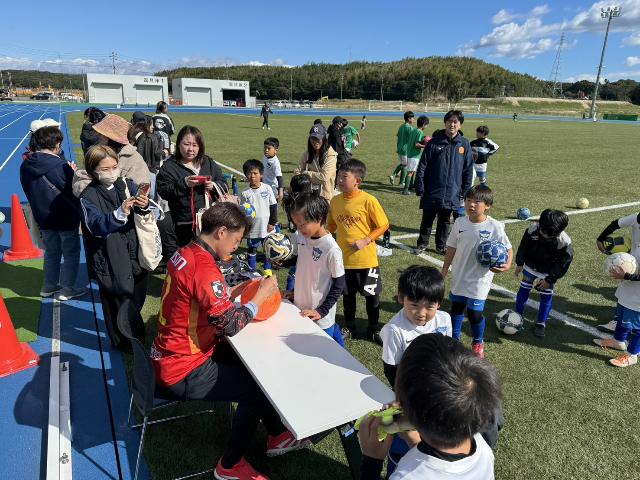 美浜町制70周年記念サッカー教室で子供たちがボールにサッカー選手のサインをもらっている様子