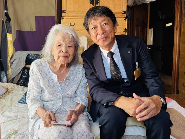 令和7年の長寿のお祝いの訪問で数え100歳と満100歳以上の高齢者の方と町長が記念写真を撮っている様子_2人目