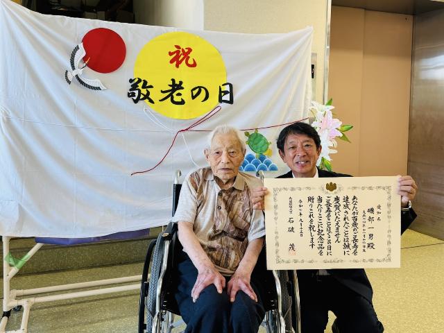 令和7年の長寿のお祝いの訪問で数え100歳と満100歳以上の高齢者の方と町長が記念写真を撮っている様子_4人目