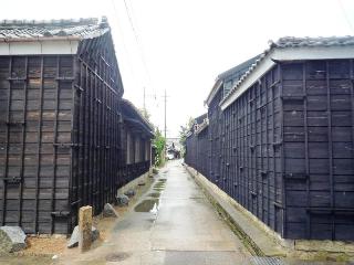 細い小道の両側に鎧壁の屋敷の建物が並んでいる趣のある街並みを写した写真