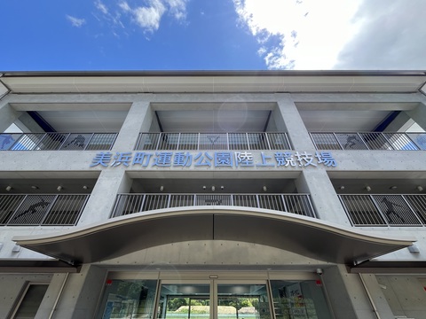 「美浜町運動公園陸上競技場」と書かれた正面玄関を見上げるように撮影した写真