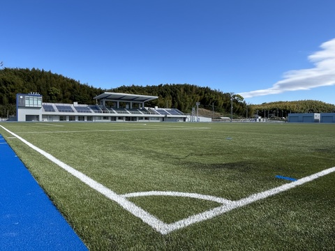観覧スタンドが向かって左側に見え、サッカーコートのコーナー部分から陸上競技場全体を撮影した写真