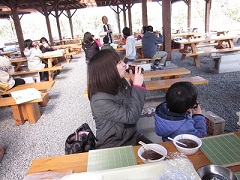 手前に座っているお母さんと子供が東北東を向き恵方巻きを食べている写真