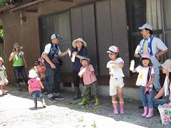 牛乳と生クリームが入ったペットボトルを振ってバターを作っている子どもたちの写真