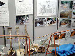 写真や説明文が展示ボードに展示されており、スコップやシート、靴などの発掘調査に必要な道具も展示されている写真