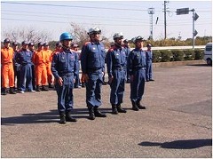 ヘルメットを被り消防活動服を着用した4人の方が横一列に整列している写真