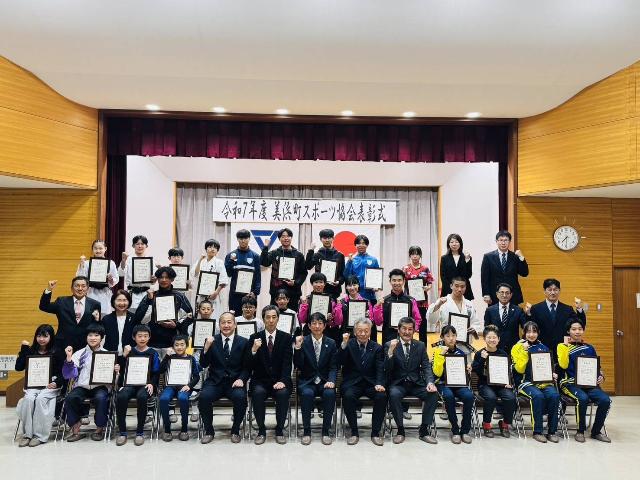 令和7年度スポーツ協会表彰式の受賞者が賞状を持ちガッツポーズしている様子