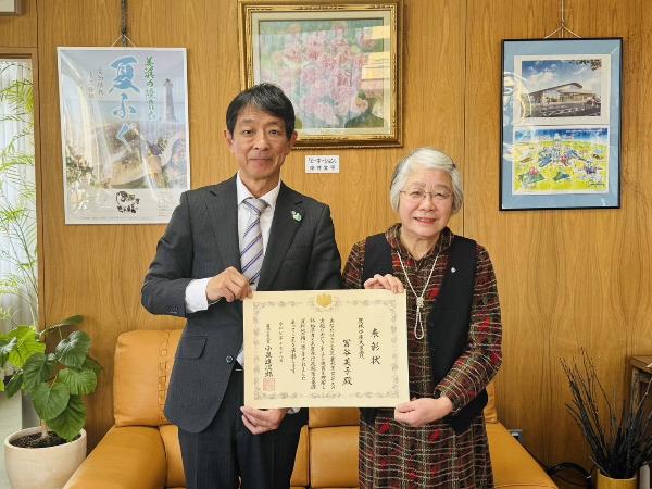 表敬訪問した冨谷美子さんと町長が賞状を持っている様子