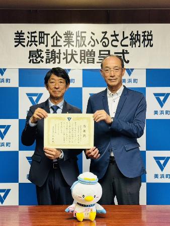 株式会社エヌアイデイの代表者と町長が感謝状をもっている様子。