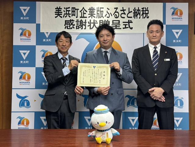 町長と有限会社名栄代表者が寄附感謝状を持ち、仲介者である名古屋銀行代表者と一緒に写っている様子
