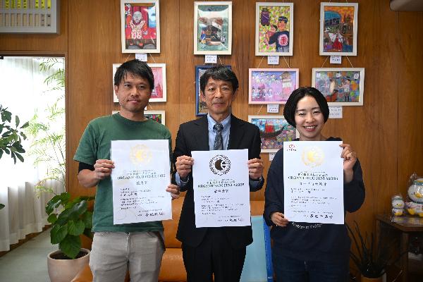 オーガニック・フェスタ2026にて受賞したポージンケンさんと杉浦大地さんが賞状をもって町長と一緒に写っている様子