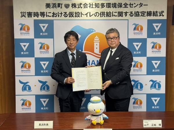 知多環境保全センター様と災害時等における仮設トイレ提供に関する協定書を締結した際、町長と代表が協定書を持ち並んで写真を撮っている様子