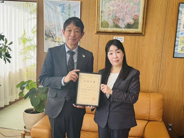 司法試験合格証書を手に持つ畠さんと町長の様子