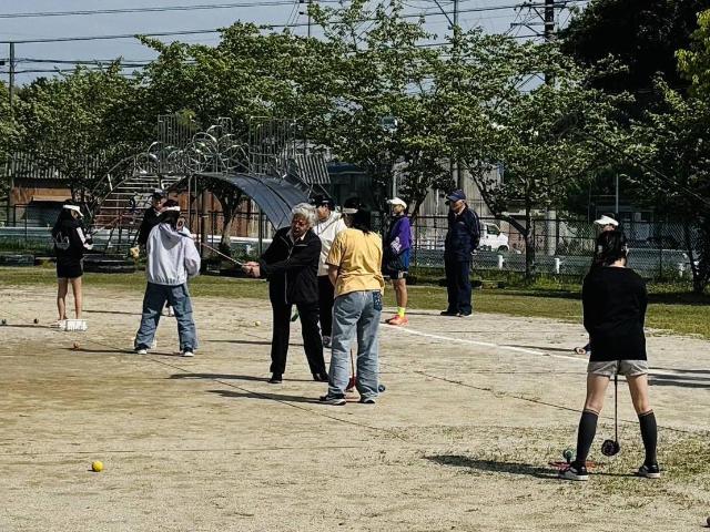 奥田小学校にて開催されたスナッグゴルフ教室で、児童がプロにボールの打ち方を教わっている様子
