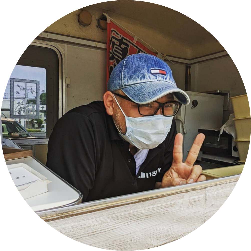 帽子を被り眼鏡とマスクした男性がピースをした写真