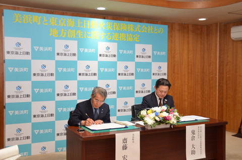 町長 齋藤宏一氏と鬼倉大助氏が協定書にサインしている写真
