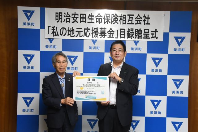齋藤宏一町長と屋和哉刈谷支社長が目録を持ち記念撮影している写真