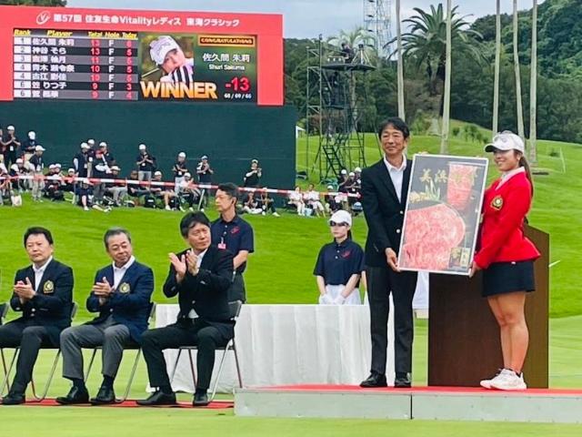優勝した佐久間朱莉プロが、町長と一緒に知多牛のパネルを持っている様子。