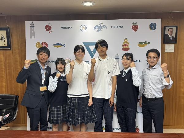 日本福祉大学付属高校和太鼓部の生徒と町長、教育長がガッツポーズで写っている様子