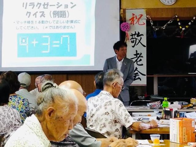一色区の敬老会で、町長が壇上で話している様子。。