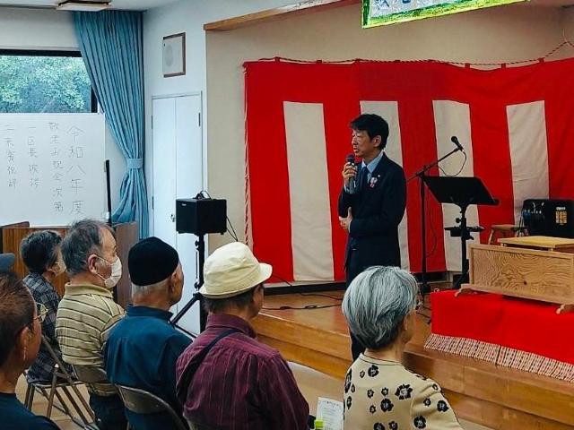 美浜緑苑区の敬老お祝いの会で、町長が参加者の前であいさつしている様子。