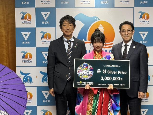 天安国際ダンスフェスティバルに出場した加藤結愛さんが表敬訪問した際に町長と教育長と並んで写真を撮っている様子