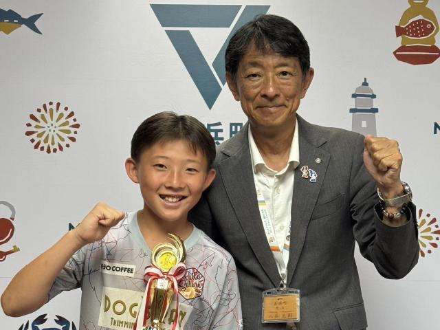 トロフィーを持ってガッツポーズする中野晃成さんと町長の様子