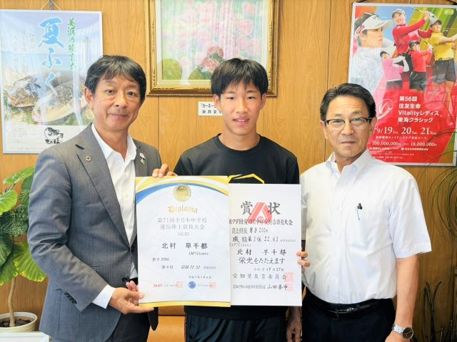陸上競技の全国大会への出場報告をした北村さんが町長と教育長と並んで写っている様子