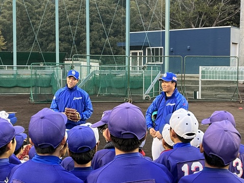 グラウンドでユニフォームに身を包んだ柳裕也投手が子ども達の前に立ち、話をしている「野球教室」の写真