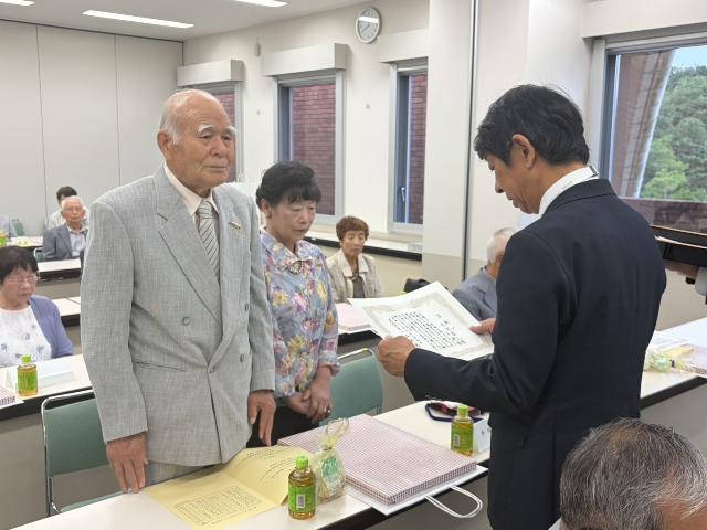 ダイヤモンド婚を祝う会で、ダイヤモンド婚を迎えられたご夫婦にお渡しする賀状を、町長が読み上げる様子。