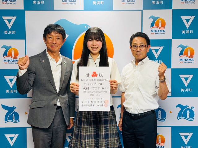 フェンシング競技大会への出場報告をした齋藤さんが町長と教育長と並んで写っている様子