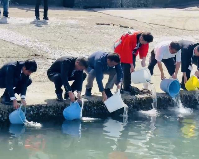 令和7年度ふぐ慰霊祭でフグを放流する様子