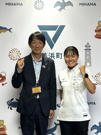 表敬訪問した林愛望さんと町長がガッツポーズしている様子