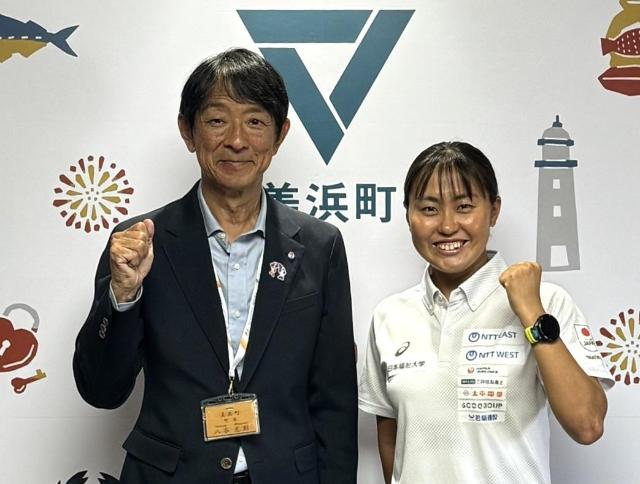 表敬訪問した林愛望さんと町長がガッツポーズしている様子