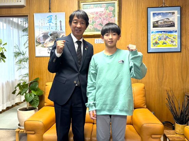 パソコン入力コンクールの全国大会出場の中村柊吾さんが表敬訪問をした際に町長と並んで写真を撮っている様子
