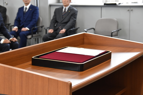 演台に置かれた当選書をメインに撮影した写真