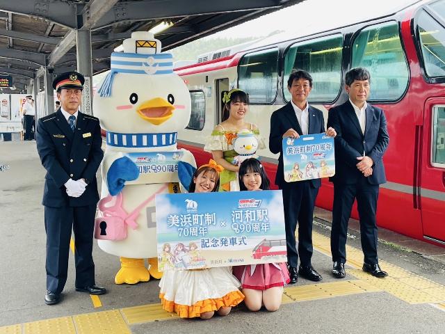 河和駅開業90周年の記念発車式で知多娘の3人とのマッキーがホームで集合写真を撮っている様子