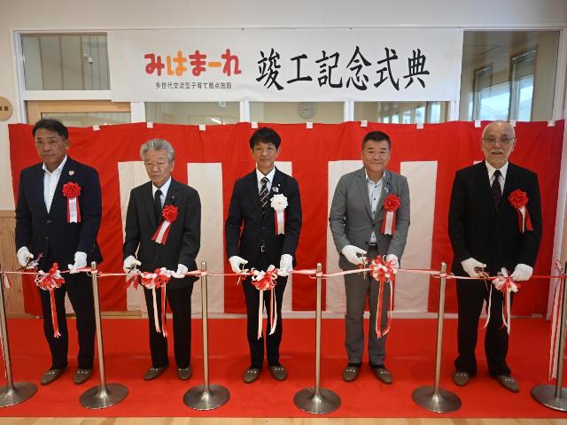 みはまーれの竣工式で、町長、横田県議、野田議長、伊藤組建設株式会社代表取締役、株式会社加藤建築事務所代表取締役がテープカットをしている様子。