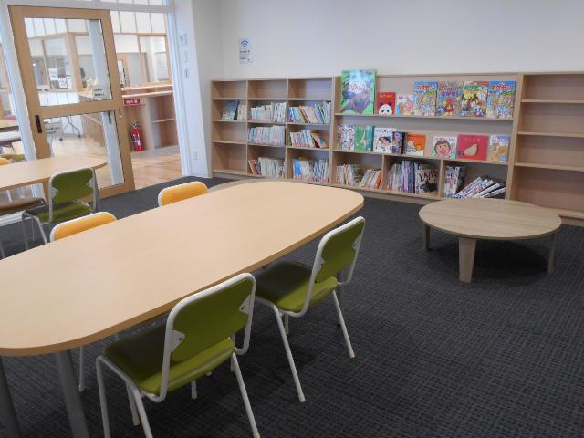 みはまーれの図書室の画像、低い机と高い机、いす、本棚に本が並んでいる様子。