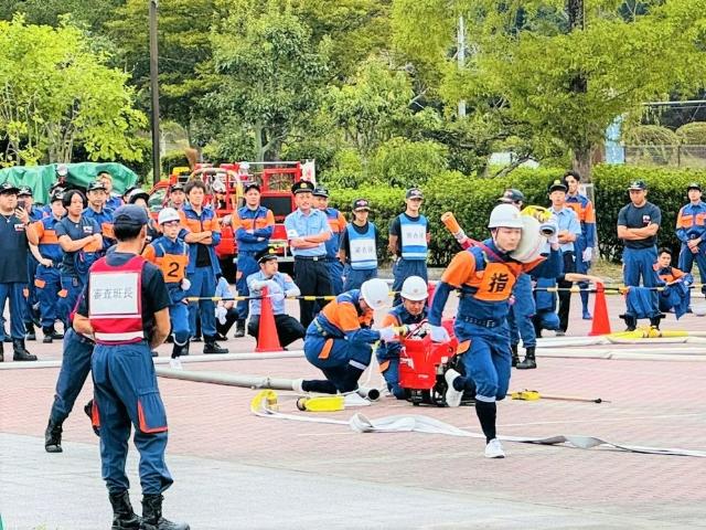 第59回美浜町消防団操法大会で指揮者がホースを担いで走っている様子