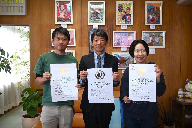 オーガニック・フェスタ2026にて受賞したポージンケンさんと杉浦大地さんが賞状をもって町長と一緒に写っている様子